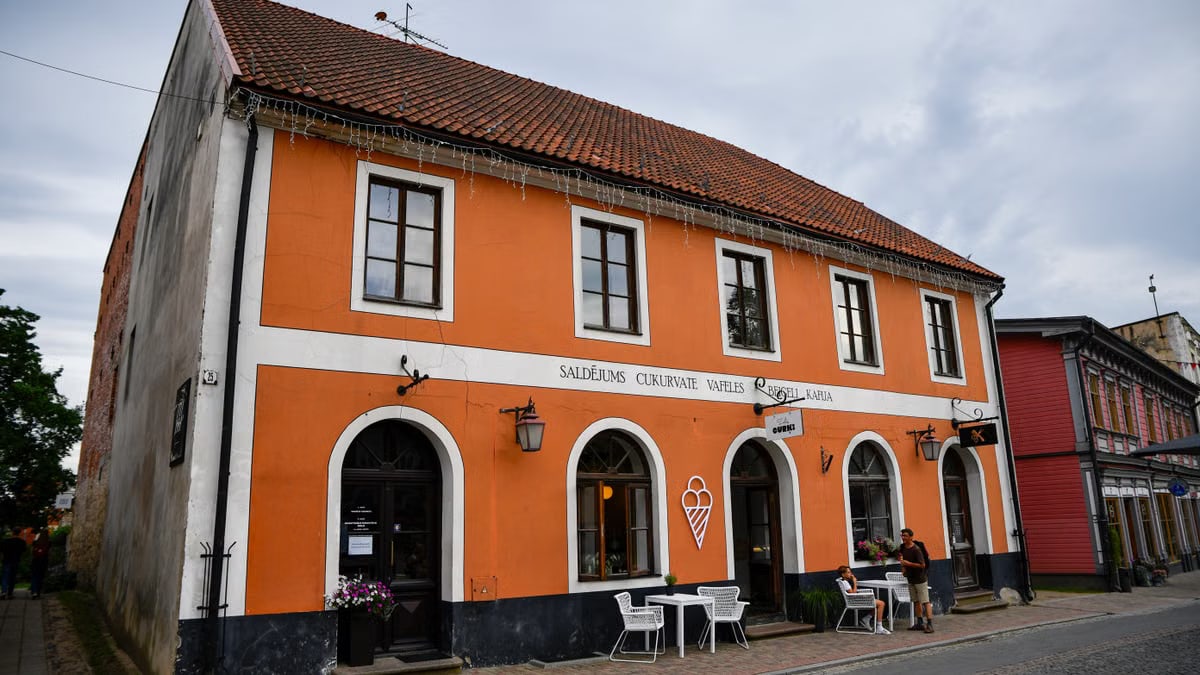 Explore the cozy ice cream shop in Cēsis, Latvia, with its vibrant orange facade.